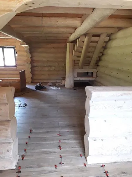 Innenraum eines Holzhauses mit sichtbaren Holzbalken